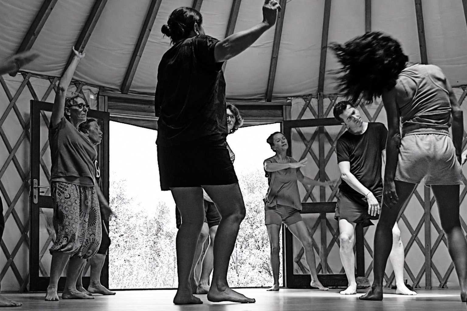 Personas adultas explorando el movimiento consciente en un taller de Cuerpo y Emoción